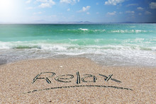 Holiday Background Or Wallpaper With Relax Word Handwritten On Beach Sand 
