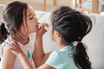 young multicultural kids doing make up pretend play