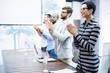 © Seventyfour - Group of positive satisfied politicians standing in row at table and applauding speaker at conference, conference table with national flags and papers