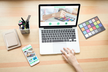 Fototapete - Businesswoman in office in casual shirt. Use computer for graphic designer and choose a color sample to match the publication.