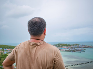 Asisn Fat Traveler stand on top of  Khao Ma Jor Pier  with Idyllic ocean beautiful white cloud endless horizon and Fishman townscape in vacation time,chonburi thailand,holiday concept