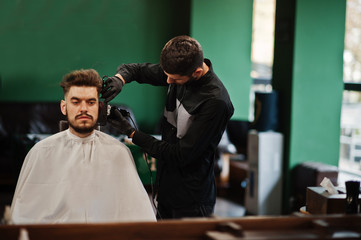 Wall Mural - Handsome bearded man at the barbershop, barber at work.