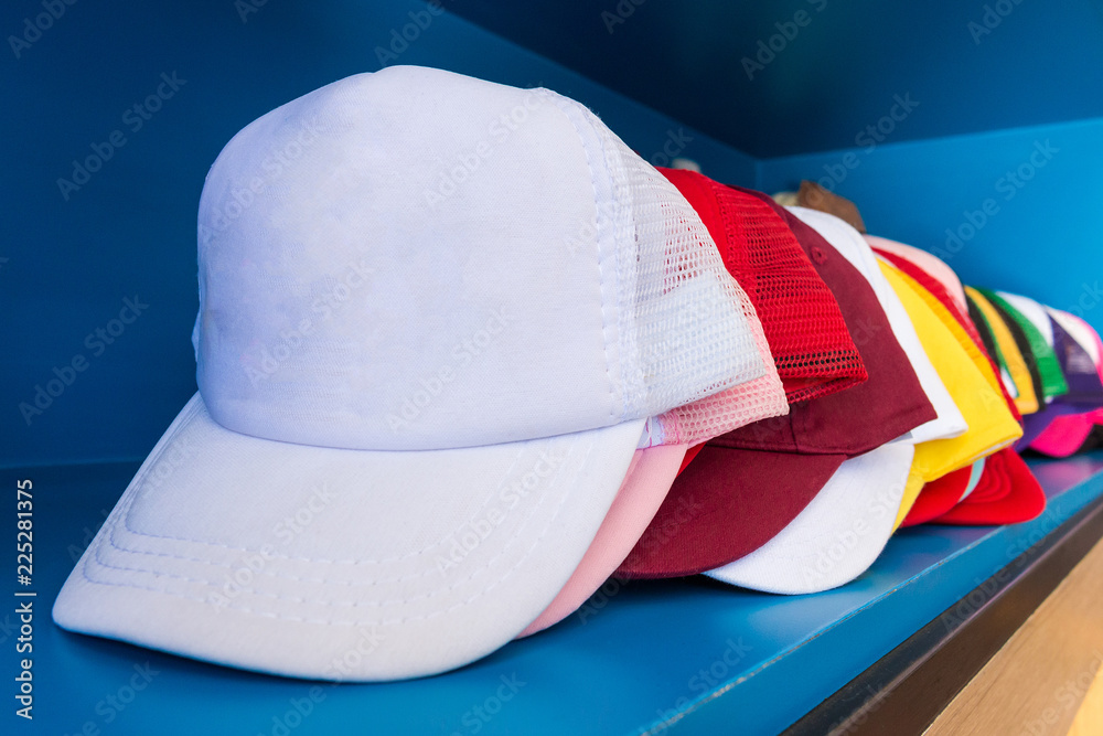 Colorful cap on blue shelf background. Fashion baseball or hiphop hat. - obrazy, fototapety, plakaty 