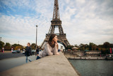 Fototapeta Paryż - Beautiful young girl in front of eiffel tower. Girl is smiling and rejoising. autumn photo