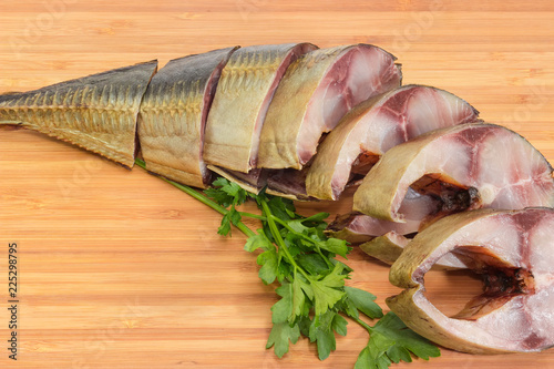 Valokuva Sliced smoked Atlantic horse mackerel on cutting board close-up