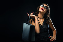 Black Friday Sale Concept. Shopping Woman Holding Grey Bag Isolated On Dark Background In Holiday