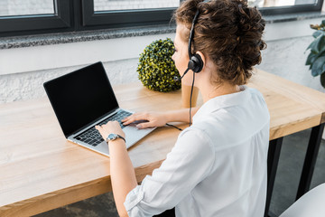 Wall Mural - young female call center operator with headset at workplace in office