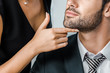 partial view of businesswoman flirting with businessman in suit