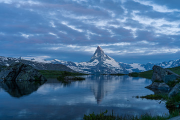 Wall Mural - Blue hour shot of the Matterhorn (Monte Cervino, Mont Cervin) pyramid and Stellisee lake. Early morning view of majestic mountain landscape. Valais Alps, Zermatt, Switzerland, Europe.