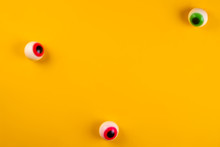Eyeball Shaped Candies With Red Pupils On Bright Yellow Background. Halloween Decor Concept. Copy Space, Close Up, Top View, Flat Lay.
