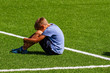© vejaa - Sad disappointed boy sitting on the grass in stadium