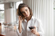 © antgor - Cute woman holding red wine glass standing in the restaurant