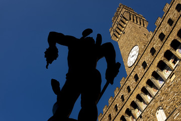 Wall Mural - backlit of Perseus with the Head of Medusa 1545 of Benvenuto Cellini, with the Palazzo Vecchio in the background, Florence