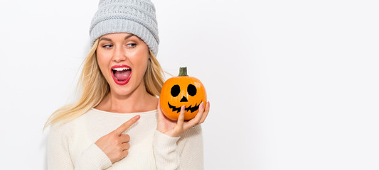 Wall Mural - Young woman holding a pumpkin on a white background