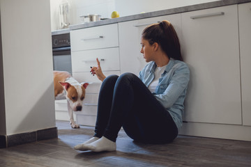 Girl scolding her dog in the kitchen