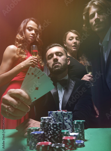 фотография concentrated men and women playing poker in casino