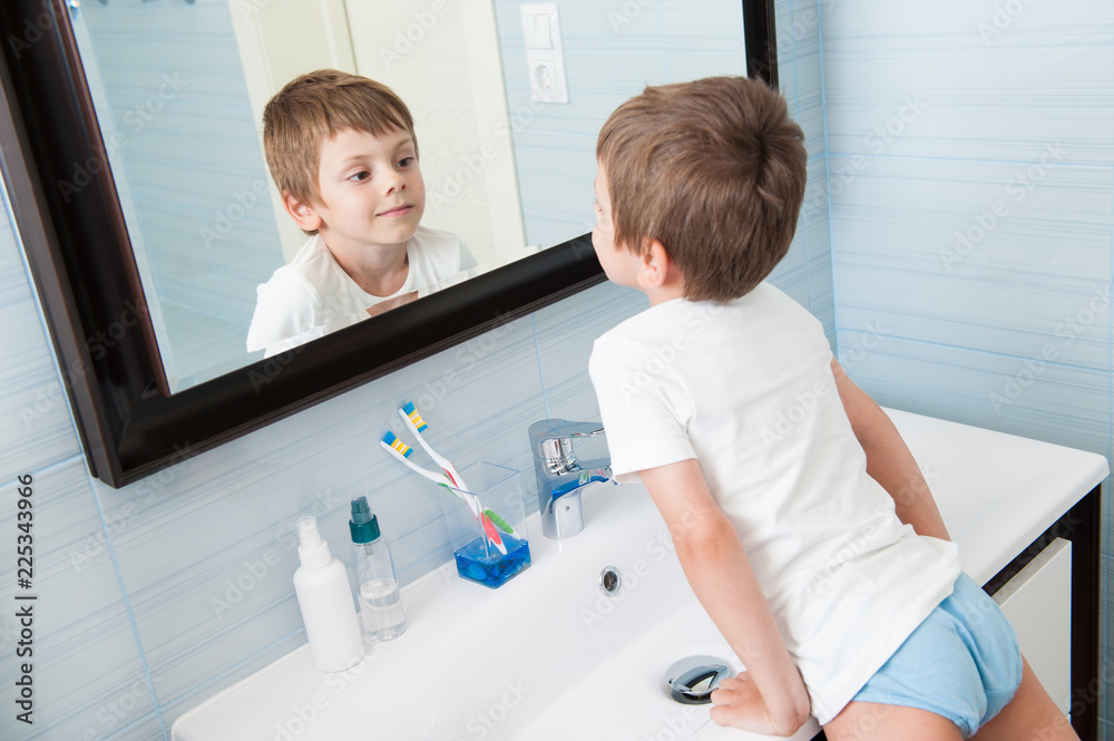 handsome-healthy-small-caucasian-boy-watching-at-his-reflection-in