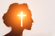 © primipil - Symbol of Christianity concept. Woman silhouette and the Cross.