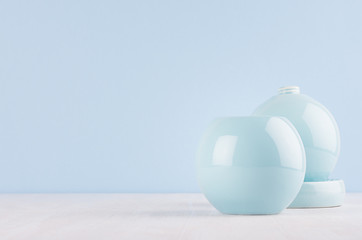 Fashion home decor in modern elegant style - light soft blue ceramic circle vases on white wood background.