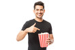 © AntonioDiaz - Smiling Attractive Male Pointing At Popcorn Bucket