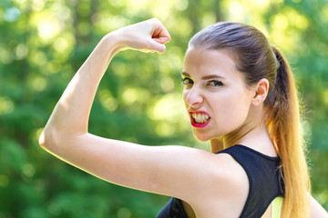 Wall Mural - Powerful young fit woman on a bright summer day in the forest