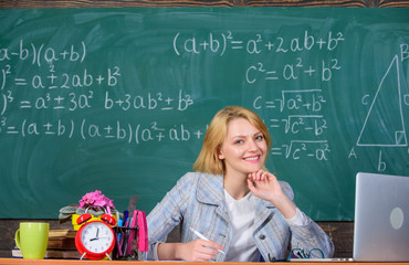 Wall Mural - Teacher woman sit table chalkboard background. Organize class and make learning easy and meaningful process. Well organized and committed teacher. Excellent communicability and interpersonal skills