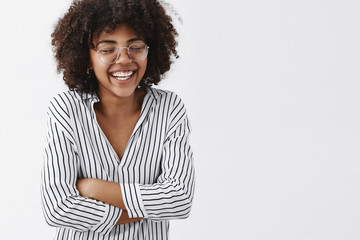Wall Mural - belly aching from laughter. amused and carefree attractive african american woman in striped blouse 