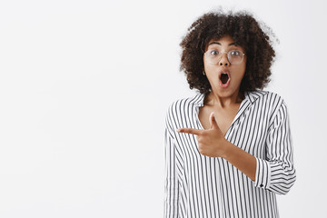 Wall Mural - speechless impressed and amazed attractive dark-skinned female coworker in striped blouse and glasse