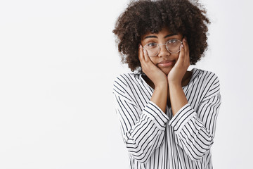 Wall Mural - waist-up shot of tired and gloomy indifferent dark-skinng young girl with afro hairstyle squeezing f