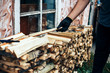 © Anastassiya  - man hold firewood, he puts cutting wood into stack of wood woodpile