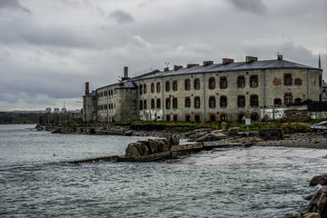 Wall Mural - Tallinn / Estonia- 15.3.2018: Old Soviet Union time prison. Sea Fortress Patarei, Patarei Prison. Stone construction by the Baltic sea. View from the sea side. abandoned looking old house.