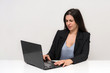 © Вячеслав Чичаев - Portrait of a beautiful brunette woman on a white background with different emotions sitting at a table with a laptop.