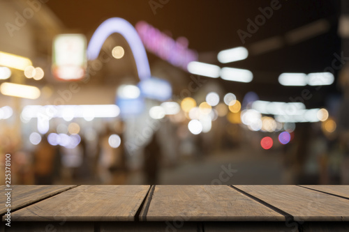 Fotografía Empty wooden table on front blurred colorful night street background, copy space