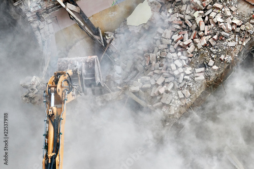 Cuadros en Lienzo Building demolition with an excavator in dust cloud.