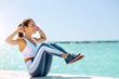 © David Gonzalez - Fit latina girl doing abs next to the Beach