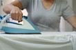 © nkeskin - Woman's hands holding hot iron, steaming clothes,shallow depth of field