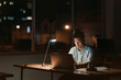 © mavoimages - Asian businessman working alone in a dark office at night