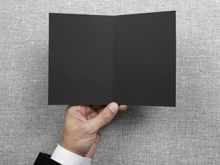 Mens hands holding empty black booklet