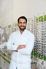 Wall Mural - Optician Man Near Showcase With Eyeglasses At Glasses Shop