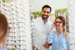 © puhhha - Eye Doctor With Woman Choosing Eyeglasses At Glasses Store