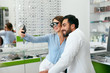 © puhhha - Eye Center. Woman Making Photo On Phone With Doctor On Eye Exam