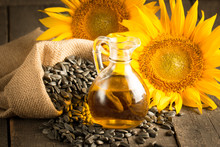 Closeup Photo Of Sunflower Oil With Seeds On Wooden Background. Bio And Organic Product Concept.