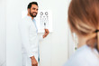 © puhhha - Vision Examination. Ophthalmologist With Eye Chart Card