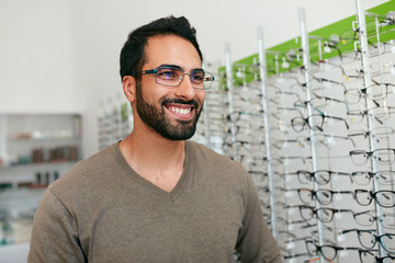 Wall Mural - Glasses Shop. Man Trying On Eyeglasses In Optics Store