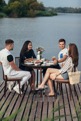 Group of happy friends gathering to having dinner together