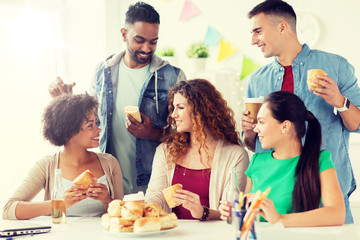 Canvas Print - corporate, celebration and people concept - happy friends or team eating sandwiches with coffee and non-alcoholic drinks at office party