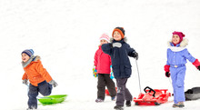 Childhood, Sledging And Season Concept - Group Of Happy Little Kids With Sleds In Winter