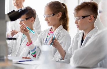 Sticker - education, science and children concept - teacher and students with test tubes studying chemistry at school laboratory