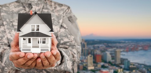 Canvas Print - Soldier Holding a Model of House