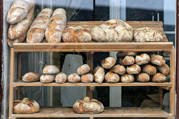 Artisan bread displayed in bakery window.